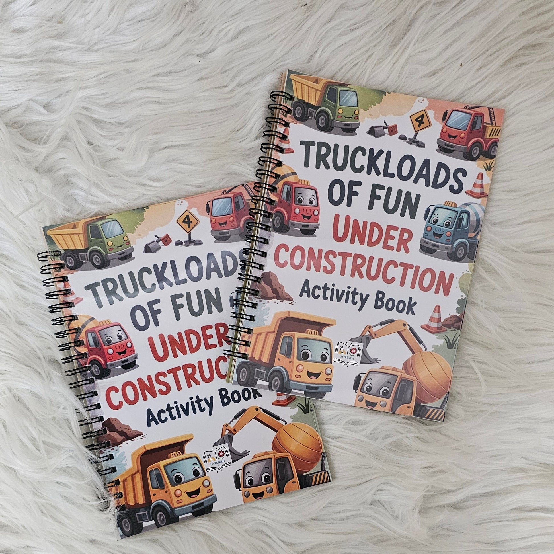 Two activity books on a white fluffy surface